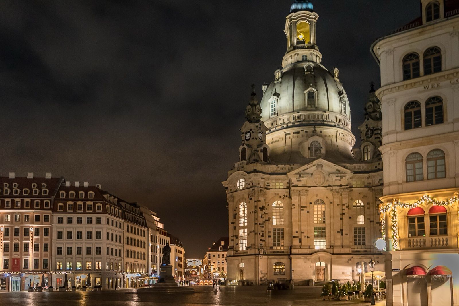 Floodlit Frauenkirche dome and Baroque facades on Dresden's Neumarkt square at night.