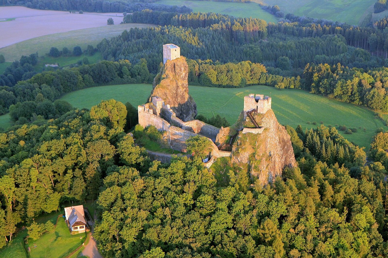 Aerial view of Trosky Castle: the two towers, Panna and Baba, on volcanic rock pinnacles above the forests of Bohemian Paradise